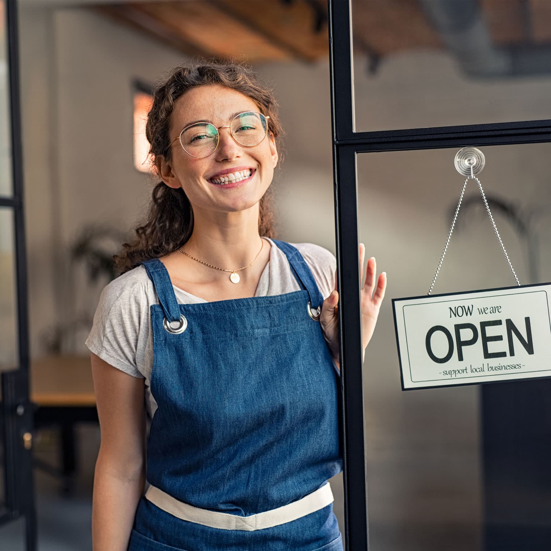 Business owner in front of open shop